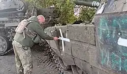 Soldier of the 17th Tank Brigade painting a cross on a captured tank