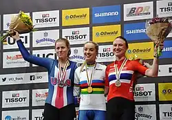 Barker stands on the podium after receiving her gold medal for victory in the points race at the 2020 World Championships