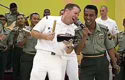 A U.S. Navy musician singing with a Malaysian Army corporal during the Cooperation Afloat Readiness and Training (CARAT) exercise. The corporal is seen wearing the No. 3 Dress with the Royal Malay Regiment stable belt.