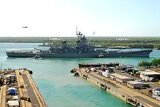 Multiple tugboats towing the battleship Missouri.