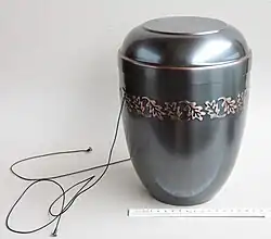 A cinerary urn. The laces are used to lower the urn into the ground