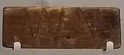 Wooden plaque with the letters "WN" carved in.