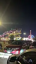 The Crazy Mouse, Mega Drop, Giant Wheel, Wave Swinger and Fire Ball pictured from a nearby parking lot in 2025