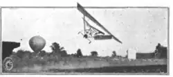 An aircraft in flight, just barely above the ground. It is banked at approximately 45 degrees.