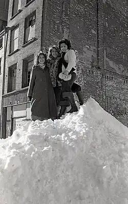 Women standing atop a snow pile in Boston