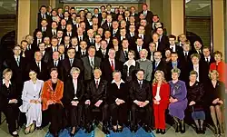 many people sitting in rows in suits and dresses