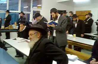Orthodox-dressed men studying