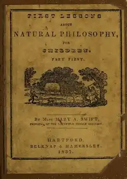 Photograph of a book cover with words at the top and bottom, surrounding a drawing of three trees in front of which stands a hay wagon and three children playing with hoops