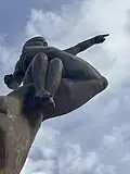 The child, held aloft by the central male figure of the African Renaissance Monument, faces outward with arms raised upward