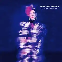 three-quarter photo of Amanda Shires wearing a red hat and lipstick with torso blurry and unclear