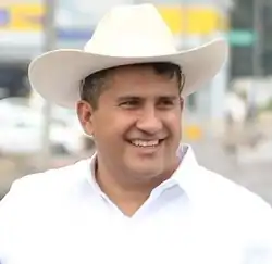 Portrait of Carlos Manzo, a man in his early forties and wearing a hat.