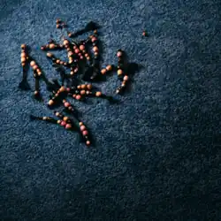 Cover art for "Girl, Get Up": tufts of beaded micro braids laid on a blue surface