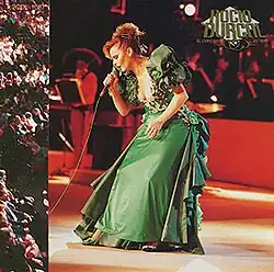 Rocío Dúrcal sings into a microphone in a green dress