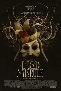 A mask of a court jester with plant roots growing from it