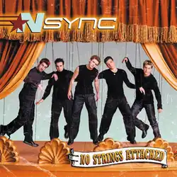 The band members are attached to rope strings posing like puppets, on top of an orange theatrical stage. The album's title is on the bottom-right corner.