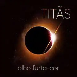 A dark sphere with a glowing light lurking from behind. The names of the band and of the album appear around it