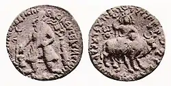 Vima standing, making an offering over a small altar. Imperial title in Greek: ΒΑΣΙΛΕΥΣ ΒΑΣΙΛΕΩΝ ΣΩΤΗΡ ΜΕΓΑΣ ΟΟΗΜΟ ΚΑΔΦΙΣΗΣ