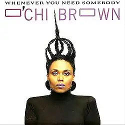 O'Chi is centered in a black shirt, with her hair up in braids, and lavendar lipstick on her mouth. The text is in a futuristic, but plain font, giving the single's name and her name. Behind her is a blinding-white background.