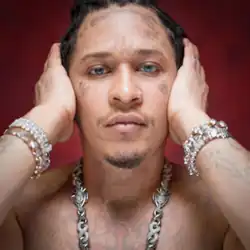 A bleached and topless Young Thug wearing jewelry and staring against a red background while covering his ears